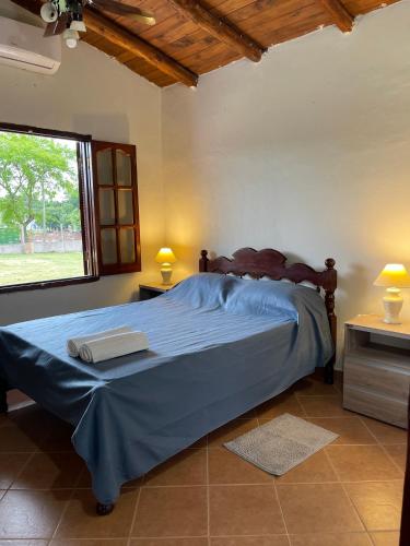 a bedroom with a bed with blue sheets and a window at Complejo Juan Pablo in Colón