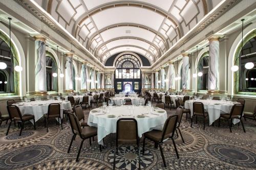 a dining room with tables and chairs and a ceiling at The Met Hotel Leeds - Newly Refurbished in Leeds