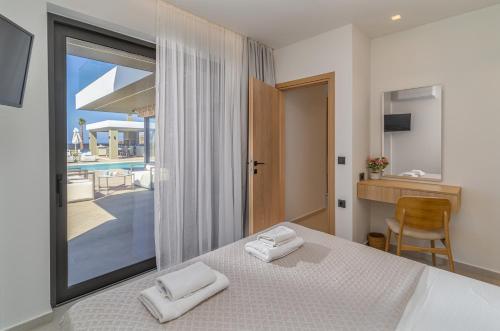 a bedroom with a bed and a view of a pool at Divel Luxury Villas with heated pools, by Estia in Anissaras