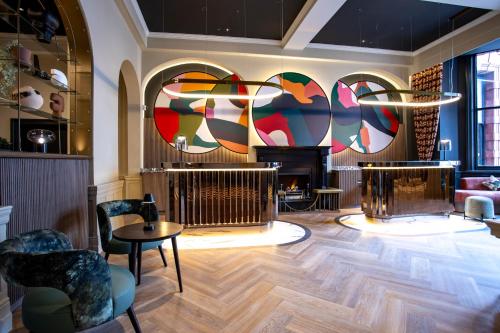a living room with a fireplace and a table and chairs at The Met Hotel Leeds - Newly Refurbished in Leeds