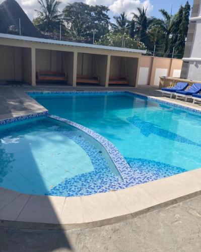 a large blue swimming pool in a building at Pamitos Sunny Paradise in Diani Beach in Diani Beach