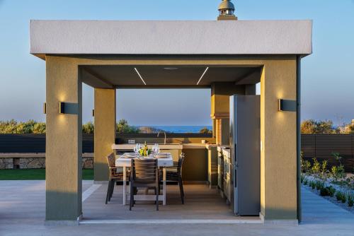 a pavilion with a table and chairs on a patio at Divel Luxury Villas with heated pools, by Estia in Anissaras