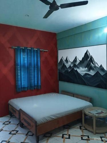 a bedroom with a bed with a painting on the wall at saraswati home stay in Pālampur