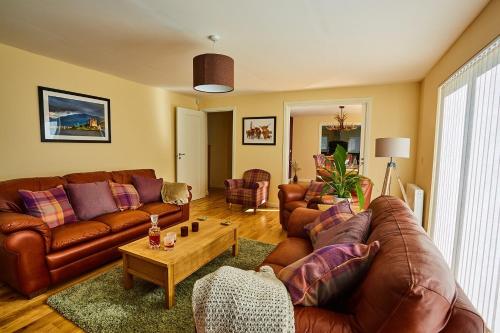 a living room with brown leather couches and a coffee table at Chapelhill in Helensburgh