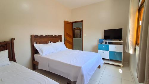 een hotelkamer met twee bedden en een televisie bij Casa Térrea em Correntina in Correntina