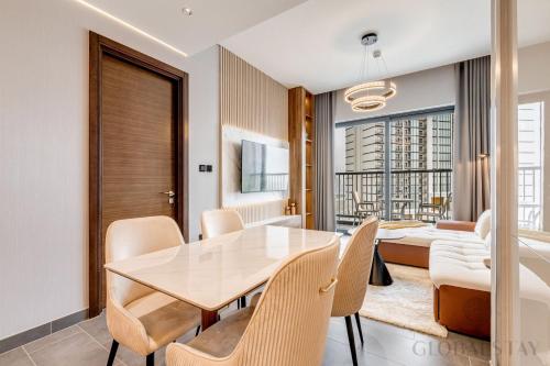 a dining room with a table and chairs and a couch at GlobalStay The Crest Tower C Apartments Dubai in Dubai