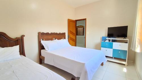 a hotel room with two beds and a television at Casa Térrea em Correntina in Correntina