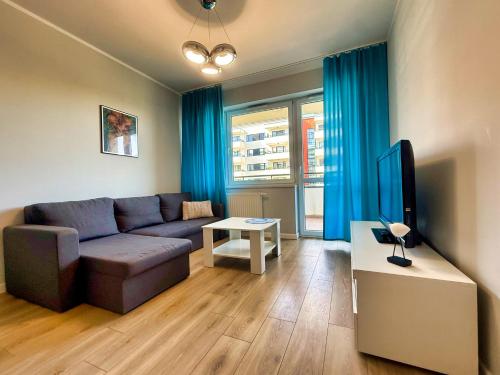 a living room with a couch and a tv at Apartament Strefa Czasu by Rentoom in Toruń