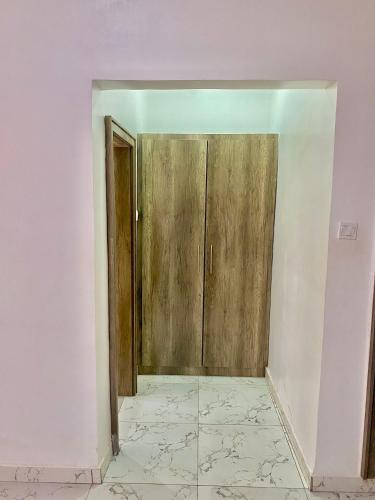 an empty room with a door and a tile floor at Fort Fountain Apartments in Abuja