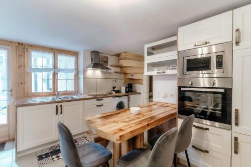 a kitchen with a wooden table and chairs at Casa Edera by Quokka 360 - Romantic Wooden House in Solduno