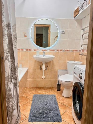 un bagno con lavandino, water e specchio di Nice&cozy flat No7 a Riga