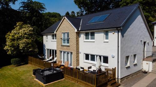 a large white house with a solar roof at Chapelhill in Helensburgh