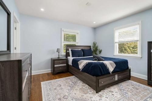 a bedroom with a bed with blue walls and a television at Spacious 6BR Getaway Game Room Firepit NYC in Elmsford