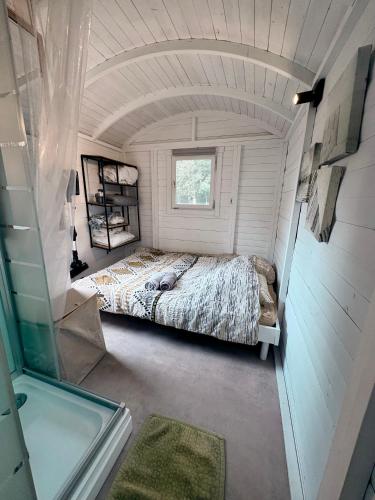 a bed in a small room with a window at La Roulotte de Papou - 2 adultes & 1 enfant in Frasnes-lez-Anvaing