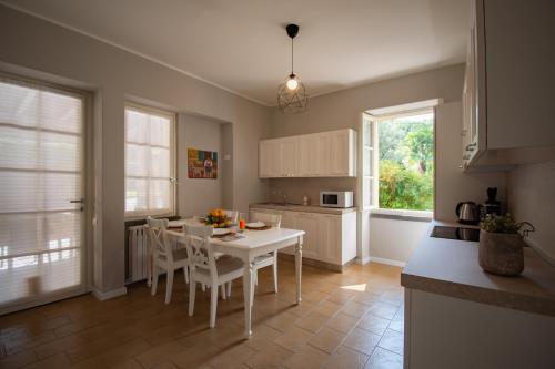 a kitchen with a white table and chairs in it at Cascina Ca' Bark in Clusane sul Lago