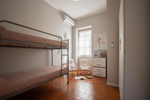 a bedroom with two bunk beds and a kitchen at Cascina Ca' Bark in Clusane sul Lago