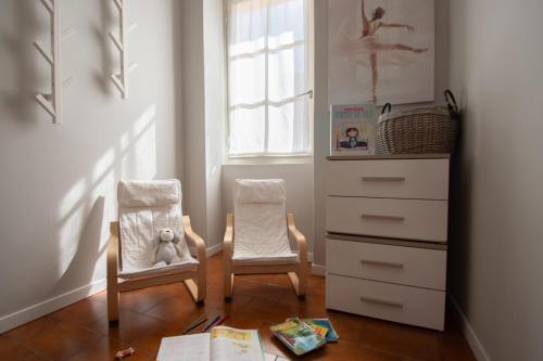 a room with two chairs and a dresser with a window at Cascina Ca' Bark in Clusane sul Lago