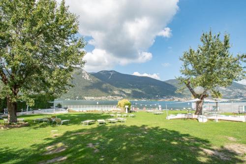a park with tables and chairs and a body of water at Cascina Ca' Bark in Clusane sul Lago