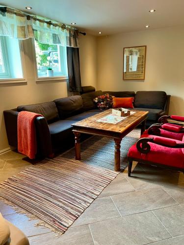 a living room with a couch and a coffee table at Hybel i underetasje 700m fra strand in Trøgstad
