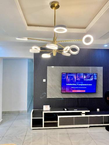 a living room with a flat screen tv on a wall at Fort Fountain Apartments in Abuja