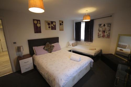 a hotel room with two beds and a couch at Holden Court Apartments - Apt 3 in West Drayton