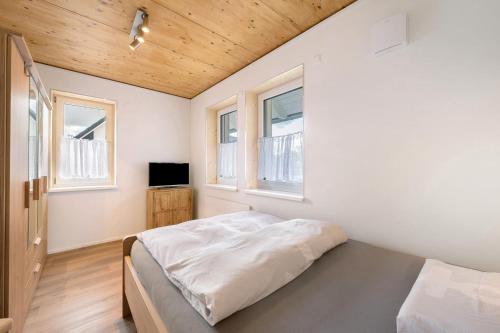 a bedroom with a bed and two windows at Ferienhäuser Stickel in Freudenstadt