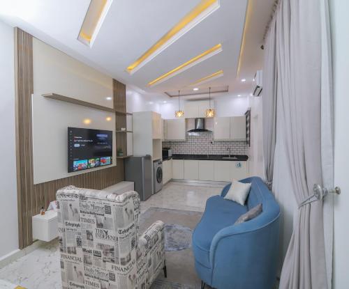a living room with two chairs and a kitchen at Fort Fountain Apartments in Abuja