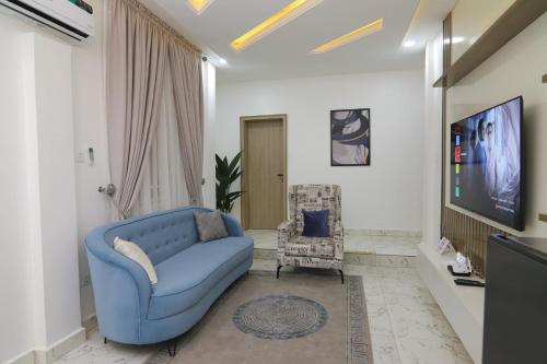 a living room with a blue couch and a chair at Fort Fountain Apartments in Abuja