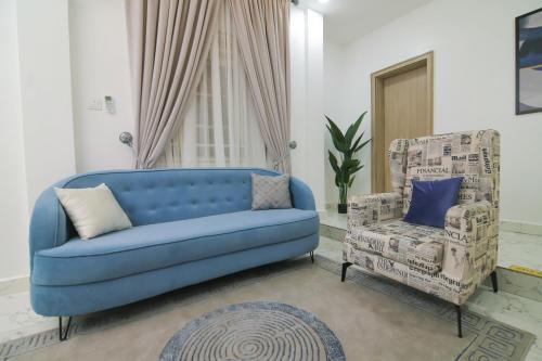 a blue couch and a chair in a living room at Fort Fountain Apartments in Abuja
