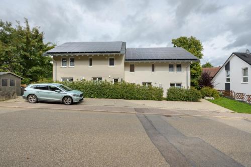 a car parked in front of a house with solar panels at Ferienhäuser Stickel in Freudenstadt