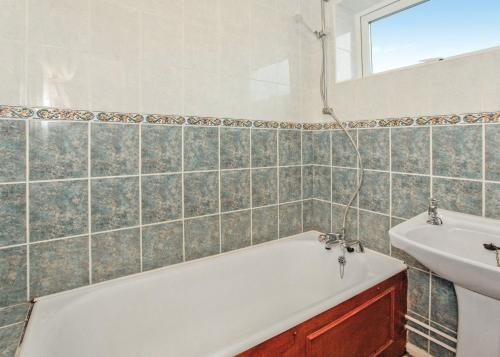 a bathroom with a tub and a sink at Anglesey Bungalows in Trearddur