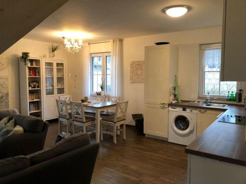 Una cocina y una sala de estar con mesa y sillas. en Ferienhaus Karola, en Kolpinsee