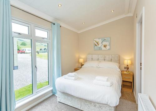 a bedroom with a bed and a large window at Bainbridge Ings in Hawes