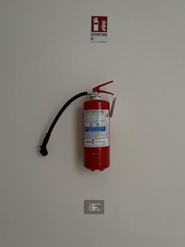 a red fire hydrant on a white wall at La valle del ciglioto in Licusati