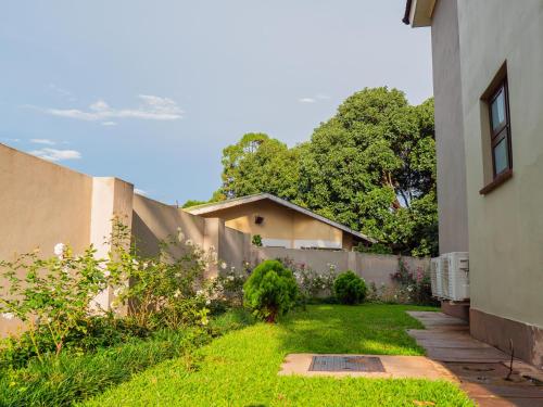a yard with a fence next to a house at Apartments at Mombo in Blantyre