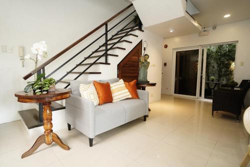 a living room with a couch and a staircase at 20 Boeing Apt in Manila