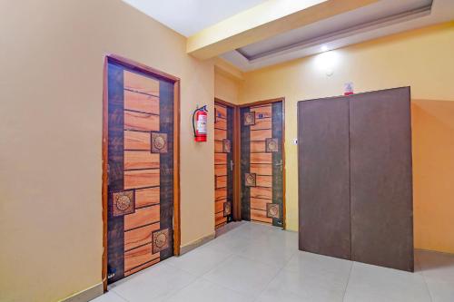 a room with two doors and a fire extinguisher at FabHotel Swagatam in Kolkata