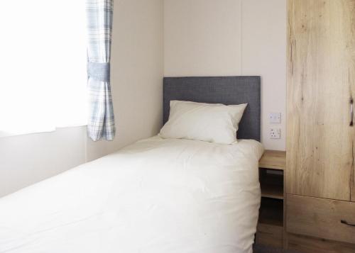 a small bedroom with a bed and a desk at Riverside Holiday Village in Uphill