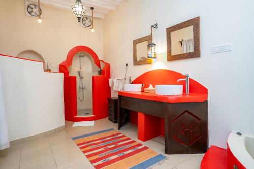 a bathroom with a red sink and a mirror at Jafferji House in Zanzibar City