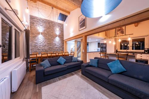 ein Wohnzimmer mit zwei Sofas und eine Küche in der Unterkunft Le Bord Du Nant in Arâches-la-Frasse
