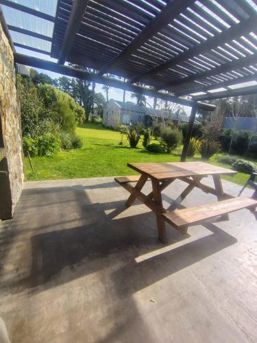 a picnic table sitting under a pavilion in a yard at Casas del Arroyo in Chapadmalal