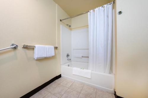 a bathroom with a shower and a white shower curtain at King City Motel by OYO Pasco in Pasco