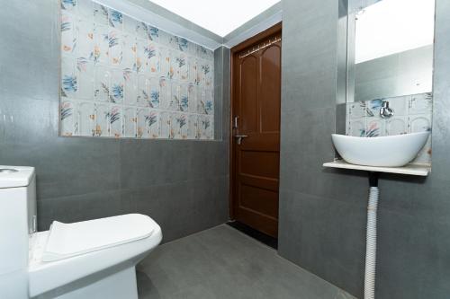 a bathroom with a white toilet and a sink at BNB By Cocasa in Varanasi