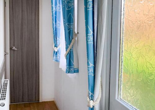 a door with blue and white curtains next to a window at Anchor Park in Happisburgh