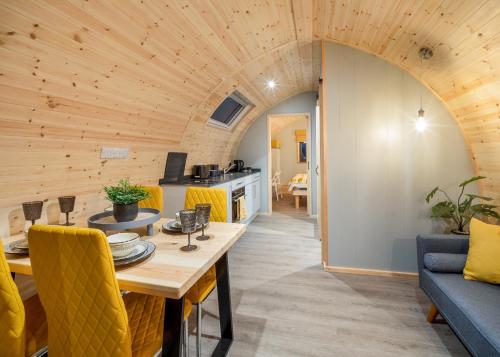 a dining room and living room with a wooden ceiling at Hill Farm Retreat in Wangford