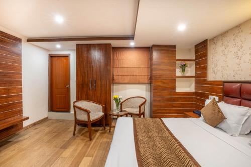 a hotel room with a bed and a table and chairs at Yashshree Jai Hotel & Banquet in Darjeeling