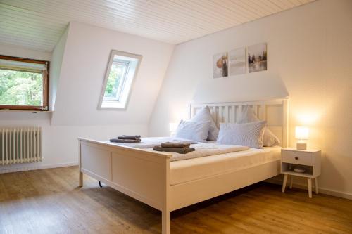 ein Schlafzimmer mit einem großen weißen Bett in einem Zimmer in der Unterkunft Holiday&Stay Black Forest Pool 85 TV WLAN in Schönwald