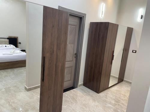 a bedroom with two wooden doors and a mirror at Grand Luxury Apartments - Downtown Cairo in Cairo