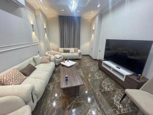 a living room with a couch and a large television at Grand Luxury Apartments - Downtown Cairo in Cairo