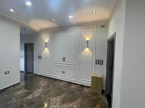 a hallway with white walls and lights on the wall at Grand Luxury Apartments - Downtown Cairo in Cairo